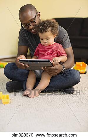 Father and toddler son using digital tablet View Large Photo Image Stock Image - Father and toddler son using digital tablet. Fotosearch