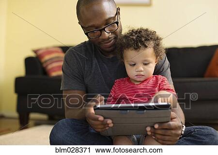 Father and toddler using digital tablet View Large Photo Image Stock Image - Father and toddler using digital tablet. Fotosearch