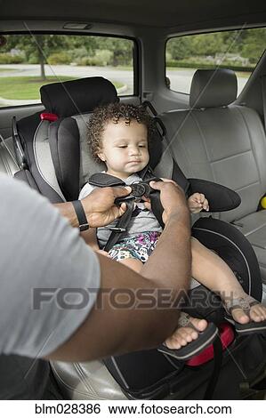 Father buckling toddler son into car seat View Large Photo Image Stock Photograph - Father buckling toddler son into car seat. Fotosearch
