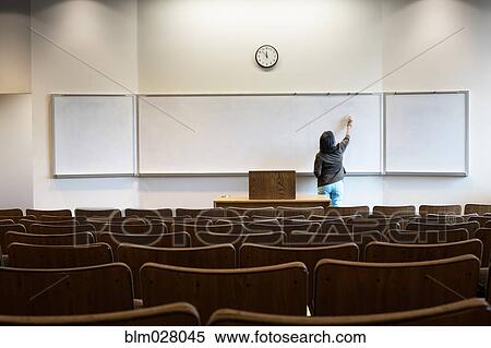 Filipino professor writing on whiteboard in empty lecture hall View Large Photo Image Stock Photography - Filipino professor writing on whiteboard in empty lecture hall. Fotosearch