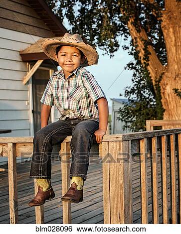 Stock Photograph - Hispanic boy wearing cowboy hat outdoors. Fotosearch