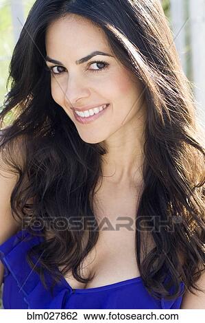 Stock Image - Hispanic woman smiling outdoors. Fotosearch