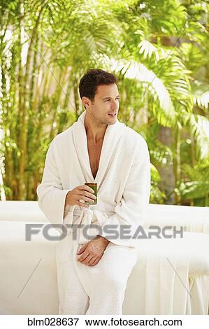 Stock Photo - Man having drink at massage table outdoors. Fotosearch