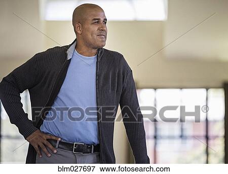 Man standing with hand on hip View Large Photo Image Stock Photo - Man standing with hand on hip. Fotosearch