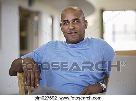 Man using laptop at desk View Large Photo Image Stock Image - Man using laptop at desk. Fotosearch