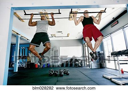 Stock Image - Men working out in gym. Fotosearch