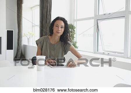 Stock Photograph - Mixed race businesswoman using digital tablet. Fotosearch