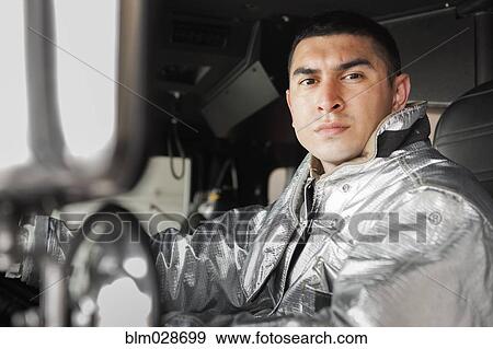 Mixed race firefighter driving fire truck View Large Photo Image Stock Photo - Mixed race firefighter driving fire truck. Fotosearch