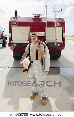 Mixed race firefighter standing by fire truck View Large Photo Image Stock Image - Mixed race firefighter standing by fire truck. Fotosearch
