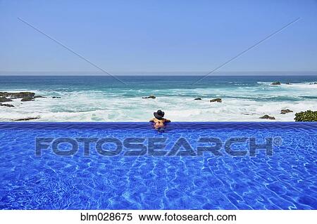 Mixed race woman relaxing in infinity pool View Large Photo Image Stock Photography - Mixed race woman relaxing in infinity pool. Fotosearch