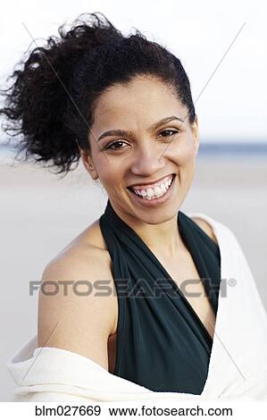 Stock Photo - Mixed race woman smiling on beach. Fotosearch