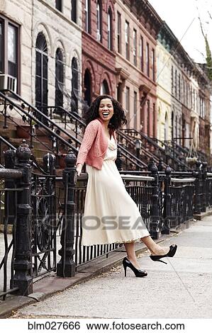 Stock Photograph - Mixed race woman smiling on city street. Fotosearch