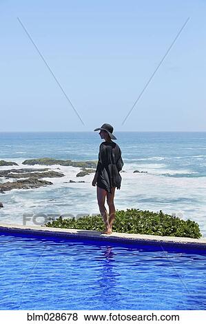 Mixed race woman walking along infinity pool View Large Photo Image Stock Photo - Mixed race woman walking along infinity pool. Fotosearch