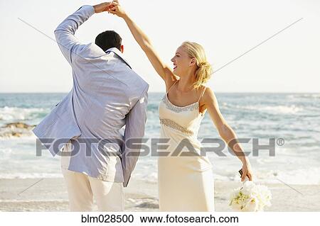 Newlywed couple dancing on beach View Large Photo Image Stock Image - Newlywed couple dancing on beach. Fotosearch