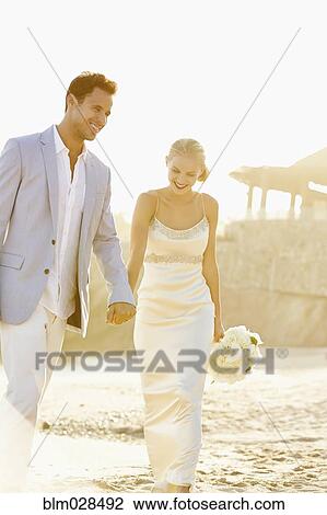 Newlywed couple holding hands on beach View Large Photo Image Stock Image - Newlywed couple holding hands on beach. Fotosearch