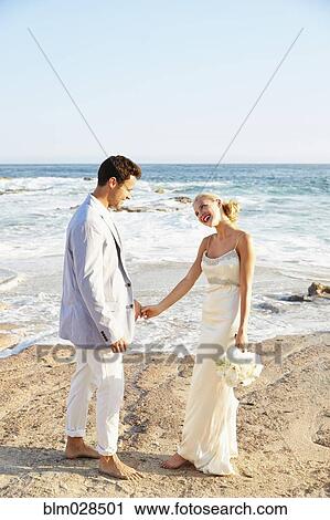 Newlywed couple holding hands on beach View Large Photo Image Stock Image - Newlywed couple holding hands on beach. Fotosearch
