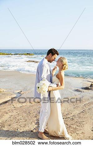 Newlywed couple hugging on beach View Large Photo Image Stock Image - Newlywed couple hugging on beach. Fotosearch