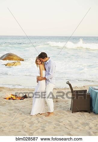 Newlywed couple hugging on beach View Large Photo Image Stock Photo - Newlywed couple hugging on beach. Fotosearch