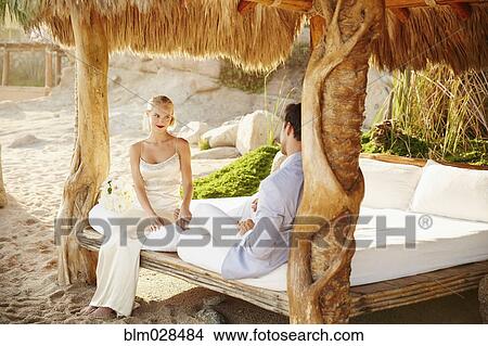 Newlywed couple relaxing in cabana View Large Photo Image Picture - Newlywed couple relaxing in cabana. Fotosearch
