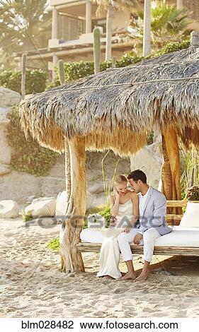 Newlywed couple relaxing in cabana View Large Photo Image Stock Image - Newlywed couple relaxing in cabana. Fotosearch