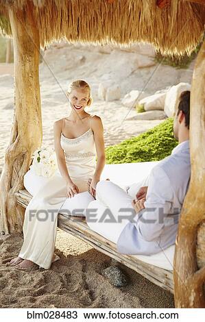 Newlywed couple relaxing in cabana View Large Photo Image Stock Image - Newlywed couple relaxing in cabana. Fotosearch