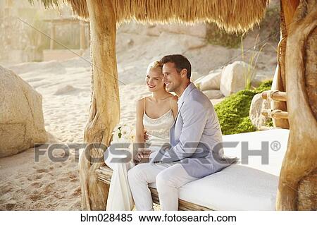 Newlywed couple relaxing in cabana View Large Photo Image Stock Photography - Newlywed couple relaxing in cabana. Fotosearch
