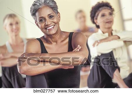 Stock Photo - Older women stretching in exercise class. Fotosearch