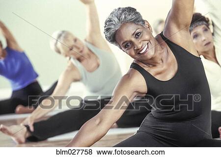 Stock Photo - Older women stretching in yoga class. Fotosearch