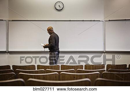 Professor standing in empty lecture hall View Large Photo Image Stock Image - Professor standing in empty lecture hall. Fotosearch