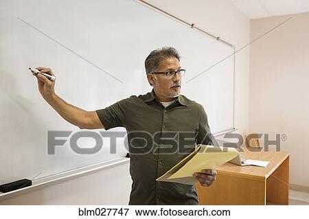 Stock Photo - Professor writing on whiteboard in classroom. Fotosearch