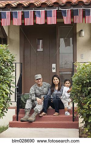 Soldier and family smiling outside house View Large Photo Image Stock Image - Soldier and family smiling outside house. Fotosearch