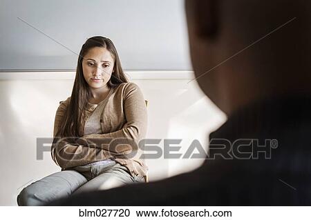 Stock Image - Student and psychologist talking in office. Fotosearch
