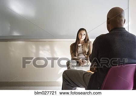 Stock Image - Student and psychologist talking in classroom. Fotosearch