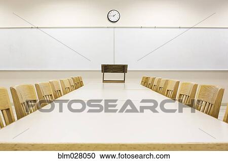 Stock Image - Tables and chairs in empty classroom. Fotosearch