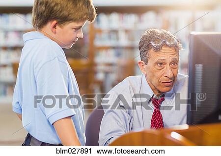 Stock Image - Teacher and student working at computer. Fotosearch