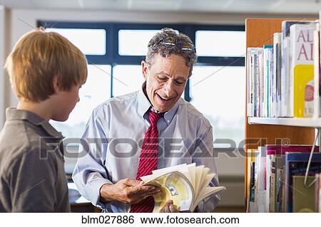 Teacher and student working in library View Large Photo Image Stock Photograph - Teacher and student working in library. Fotosearch
