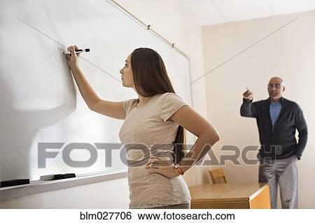 Teacher instructing student at whiteboard View Large Photo Image Stock Photograph - Teacher instructing student at whiteboard. Fotosearch