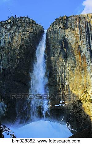 Stock Image - Waterfall over sheer rocky cliffs, Yosemite, California, United States. Fotosearch
