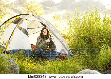 Woman drinking coffee in tent at campsite View Large Photo Image Stock Image - Woman drinking coffee in tent at campsite. Fotosearch