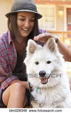 Stock Photo - Woman petting dog outdoors. Fotosearch