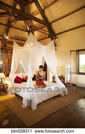 Stock Image - Woman relaxing in hotel room. Fotosearch