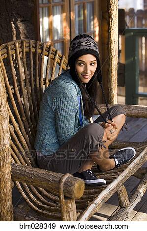 Woman sitting in armchair on porch View Large Photo Image Stock Photo - Woman sitting in armchair on porch. Fotosearch