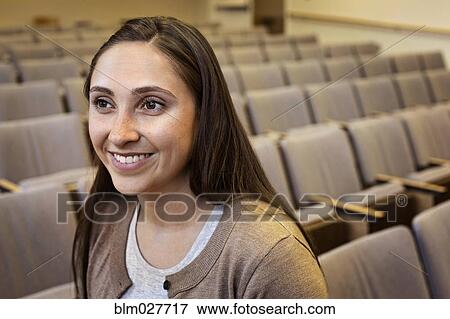 Stock Photo - Woman smiling in lecture hall. Fotosearch