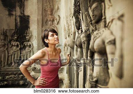 Stock Photograph - Woman visiting ancient temple, Angkor, Siem Reap, Cambodia. Fotosearch