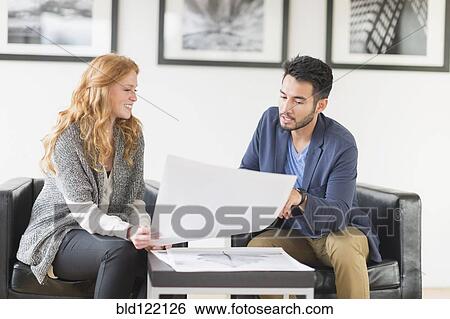 Stock Photograph - Artist and gallery owner talking in art gallery. Fotosearch