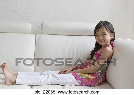 Asian girl relaxing on sofa View Large Photo Image Stock Photography - Asian girl relaxing on sofa. Fotosearch