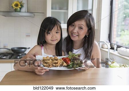 Asian mother and daughter cooking together View Large Photo Image Stock Photo - Asian mother and daughter cooking together. Fotosearch