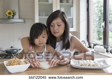 Stock Photography - Asian mother and daughter cooking together. Fotosearch