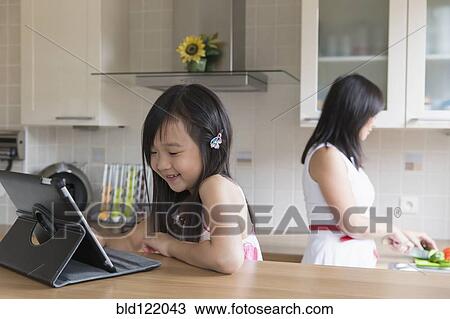 Asian mother and daughter in kitchen View Large Photo Image Stock Image - Asian mother and daughter in kitchen. Fotosearch
