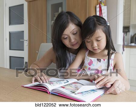 Asian mother and daughter reading together View Large Photo Image Stock Image - Asian mother and daughter reading together. Fotosearch